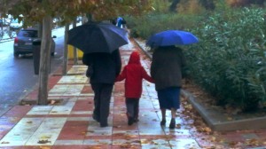 Foto de abuelos y nieto en Madrid, un día de lluvia.